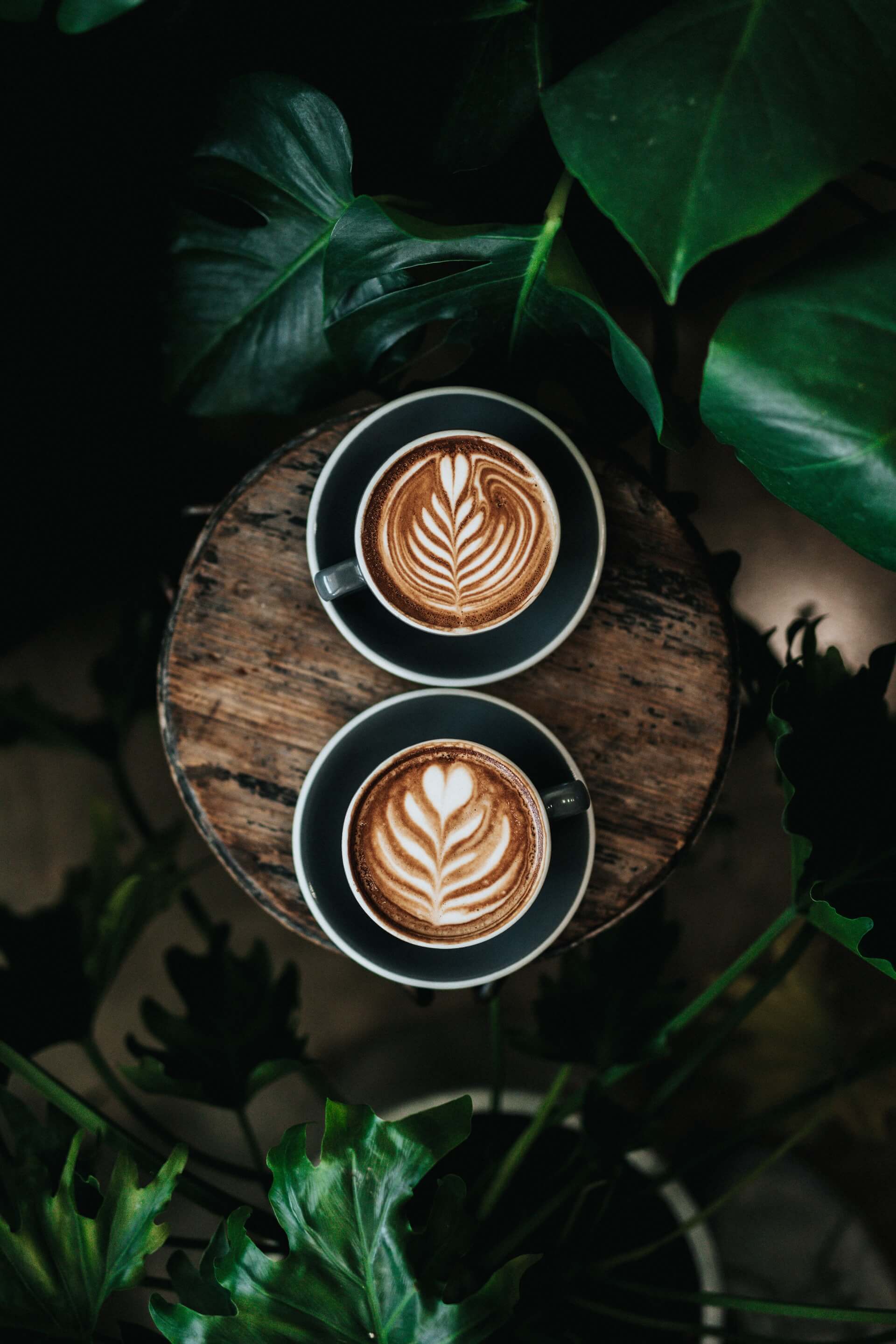 Two cups of coffee on a wooden table.