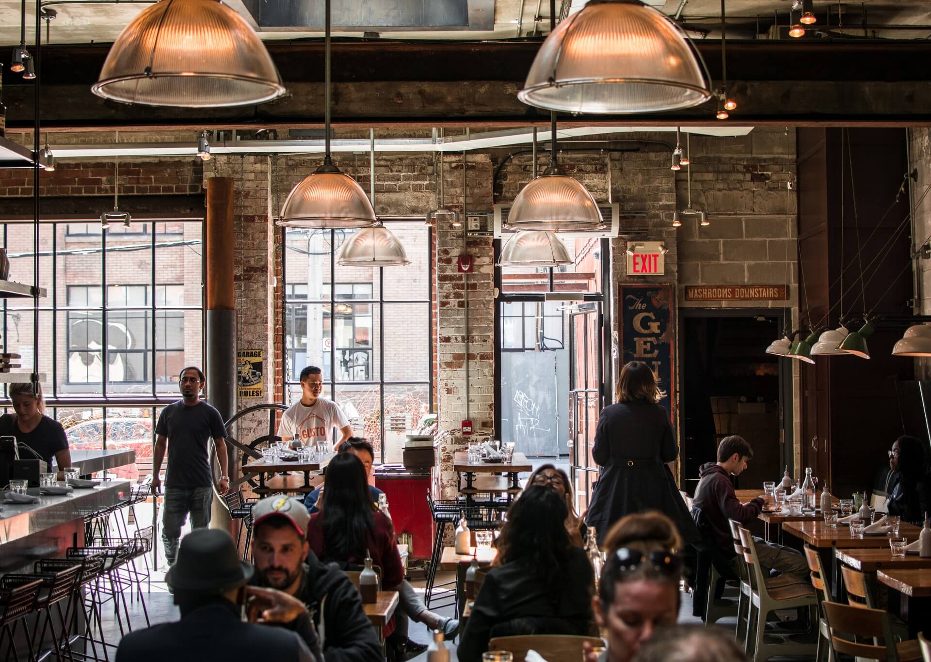 A coffee shop with people seated at tables.